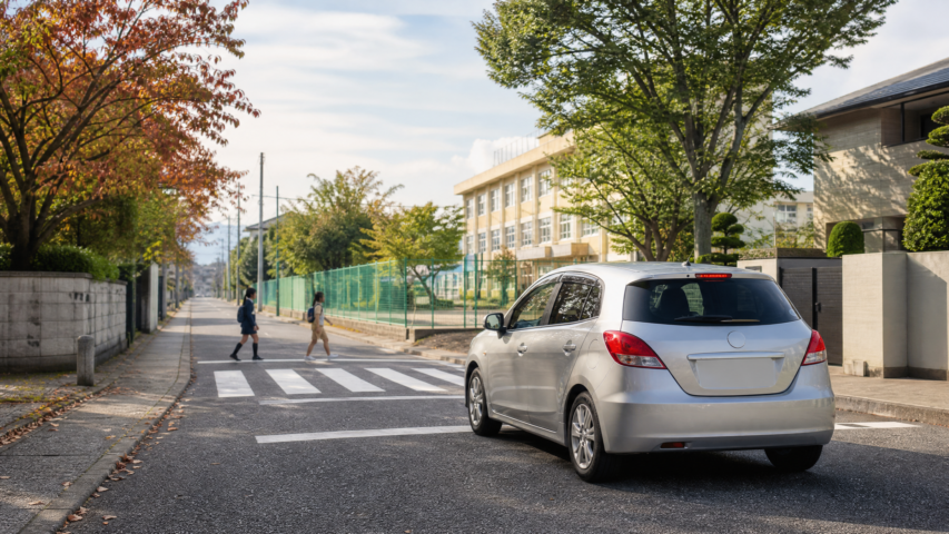 Rental car approaching a Japanese school-area pedestrian crossing safely